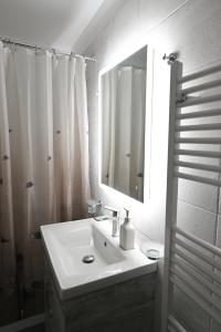 uma casa de banho branca com um lavatório e um espelho em Lefkakia Unique Holiday Villa em Levkákia