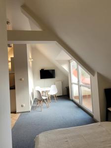 a attic room with a table and a tv at Romanówka in Kołobrzeg