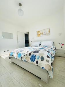 Schlafzimmer mit einem Bett mit einer blauen und weißen Bettdecke in der Unterkunft MaurusHome come a casa tua. in Fiumicino