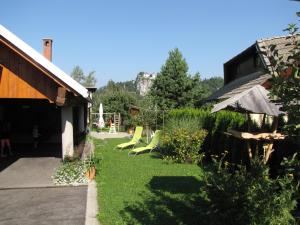 un patio con sillas verdes y una casa en Apartma Zo-Vi Bled, en Bled