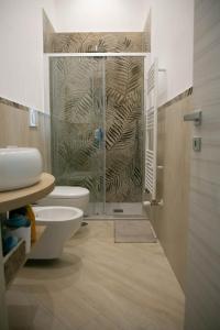 a bathroom with a toilet and a glass shower at Camerelle Apartments - casa vacanze in Castellammare di Stabia
