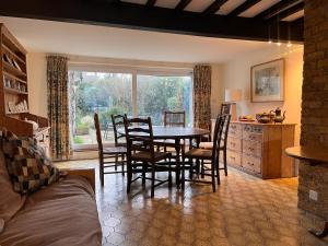 a dining room with a table and chairs and a window at Ivy Cottage in West Mersea