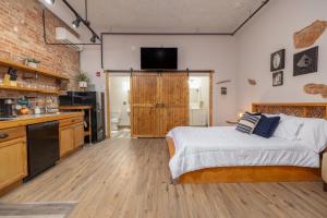 a bedroom with a bed and a kitchen with a television at Hartwell Suites in Hartwell