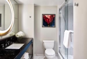 a bathroom with a toilet and a glass shower at Grand Bohemian Hotel Orlando, Autograph Collection in Orlando