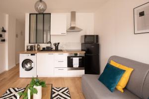 a living room with a couch and a kitchen at Appartement lumineux proche Parc de la Villette in Paris