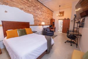 a bedroom with a bed and a brick wall at Hartwell Suites in Hartwell