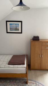 1 dormitorio con 1 cama y armario de madera en Villa Pluto en Gnjilane