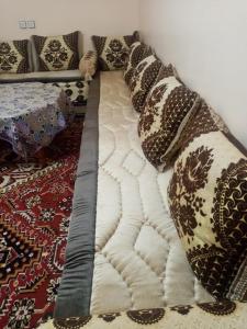 Bett mit Kissen darauf in einem Zimmer in der Unterkunft Dar El Ghali in Er Rachidia