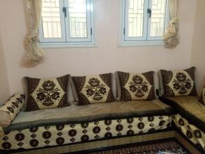 ein Sofa mit Kissen darauf im Wohnzimmer in der Unterkunft Dar El Ghali in Er Rachidia