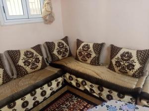 ein Sofa mit Kissen darauf im Wohnzimmer in der Unterkunft Dar El Ghali in Er Rachidia