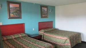 a hotel room with two beds and two pictures on the wall at Sportsman's Motel in Eagle Lake