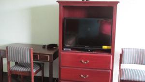 un centro de entretenimiento rojo con TV y escritorio en Sportsman's Motel, en Eagle Lake