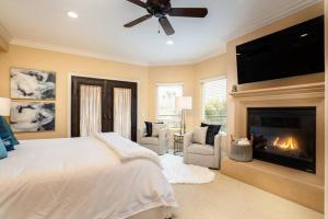 a bedroom with a large bed and a fireplace at Luxury Beach House Rooftop Deck in Huntington Beach