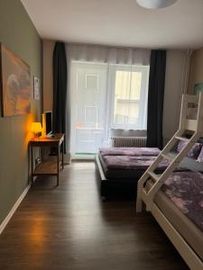 a bedroom with two beds and a desk and a window at BERLIN PUR - Wohnung für bis zu 12 Personen in Berlin