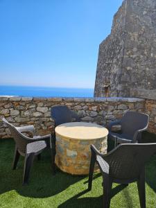 um pátio com cadeiras, uma mesa e uma parede de pedra em Rigas stone tower east Mani 3 em Mína