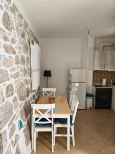 uma mesa e cadeiras numa cozinha com uma parede de pedra em Rigas stone tower east Mani 3 em Mína