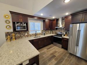 Una cocina con gabinetes de madera y un refrigerador de acero inoxidable. en Timber Top Terrace - Huge Luxury 6 BR - Sleeps 16 Linens and Towels Included, en Albrightsville 90 fotos más