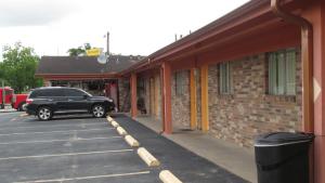 un coche negro aparcado en un estacionamiento junto a un edificio en Sportsman's Motel, en Eagle Lake