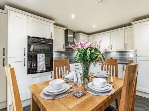 a kitchen with a wooden table with chairs and a vase of flowers at 2 bed property in Horncastle 86663 in Horncastle