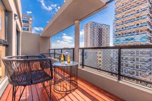 uma varanda com cadeiras e mesas e vista para a cidade em Modern Apartments in Palermo em Buenos Aires