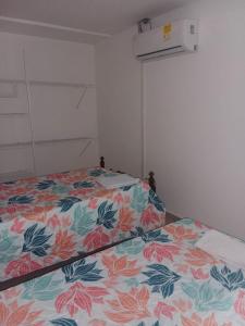 a bedroom with a bed with a floral bedspread at PARTAMENTO VALLEDUPAR in Valledupar