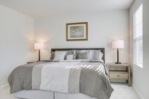 ein weißes Schlafzimmer mit einem großen Bett und zwei Lampen in der Unterkunft Clayton Townhome about 13 Mi to Downtown Raleigh! in Garner