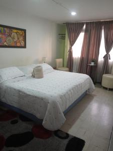 1 dormitorio con 1 cama blanca grande con cortinas en HOTEL GALICIA PLAZA, en Manizales