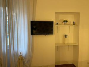 a flat screen tv on a wall next to a window at Charming Canonica Apartments in Milan