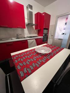 una cocina con armarios rojos y una mesa con un plato. en Stylish flat in San Giovanni Lupatoto, en San Giovanni Lupatoto