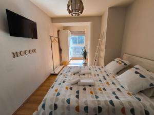 1 dormitorio con 1 cama y TV en la pared en Ideal Parejas - Tranquilidad y naturaleza - Vistas al lago en Osséja