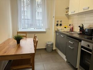 una pequeña cocina con mesa de madera, mesa y ventana en BERLIN PUR - Wohnung für bis zu 12 Personen, en Berlín