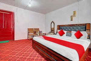 OYO Flagship Rest A While في سريناغار: غرفة نوم بسرير كبير ومخدات حمراء