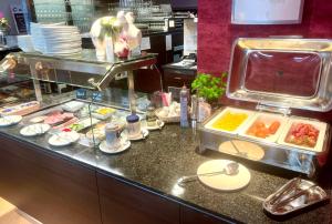 a buffet line in a restaurant with food at Garni Hotel Henn in Simmerath