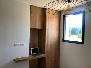 a room with a laptop on a shelf with a window at Villa de 4 chambres avec piscine privee terrasse et wifi a Malaucene in Malaucène