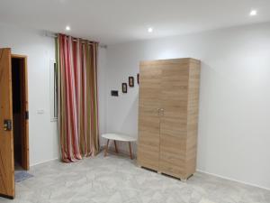um quarto com um armário de madeira e uma mesa em Appartement S+0 a borj cedria erriadh em Potinville