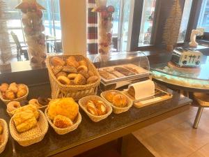 ein Buffet mit Körben mit Brot und Gebäck auf dem Tisch in der Unterkunft Garni Hotel Henn in Simmerath