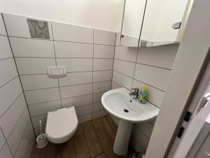 een witte badkamer met toilet en wastafel bij Neat 1BR Apt. Simmering - Ideal for Longstays in Wenen