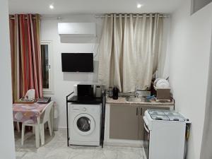 uma cozinha com uma máquina de lavar roupa e um lavatório em Appartement S+0 a borj cedria erriadh em Potinville