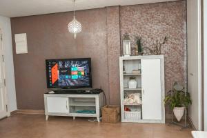 sala de estar con TV de pantalla plana en un estante en 4 bedrooms property at San Juan de los Terreros 30 m away from the beach with wifi, en San Juan de los Terreros