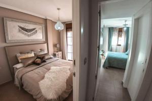 1 dormitorio con cama y espejo en 4 bedrooms property at San Juan de los Terreros 30 m away from the beach with wifi, en San Juan de los Terreros