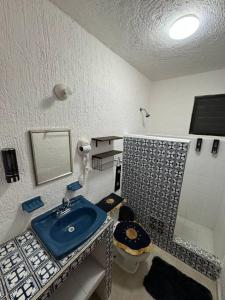 a bathroom with a blue sink and a toilet at Casa Marina in Cancún