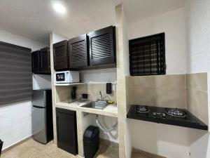 uma pequena cozinha com um lavatório e um fogão em Casa Marina em Cancún