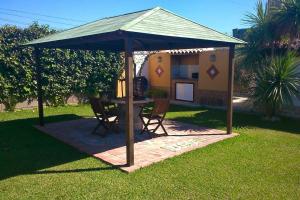 um gazebo com uma mesa e cadeiras num quintal em 2 bedrooms property at Sanlucar de Barrameda 2 km away from the beach em Sanlúcar de Barrameda