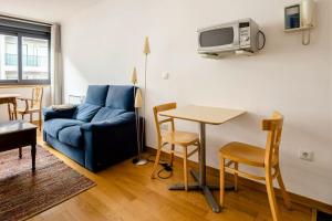 a living room with a blue couch and a table at One bedroom appartement with wifi at Baiona in Baiona