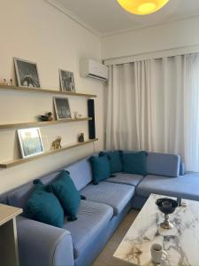 a living room with a blue couch and a table at Maria Louiza apartment NEAR CENTER in Athens