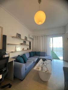 uma sala de estar com um sofá azul e uma mesa em Maria Louiza apartment NEAR CENTER em Atenas