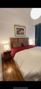 a bedroom with a large white bed with two lamps at Maria Louiza apartment NEAR CENTER in Athens