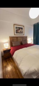Un dormitorio con una gran cama blanca con dos lámparas. en Villa Maria Louiza apartment NEAR CENTER, en Atenas
