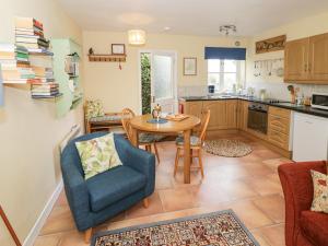una cucina e una sala da pranzo con tavolo e sedie di The Garden Lodge a Bridgnorth