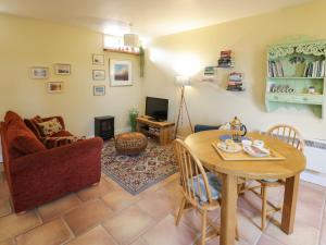 un soggiorno con un tavolo e una sedia di The Garden Lodge a Bridgnorth